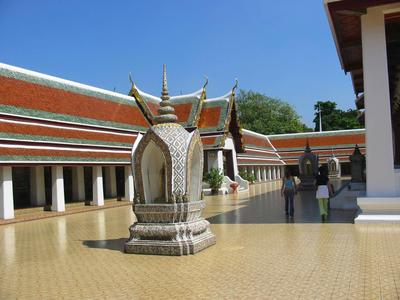Ampia corte con pietra bianca e tetto tradizionale di tempio thailandese.