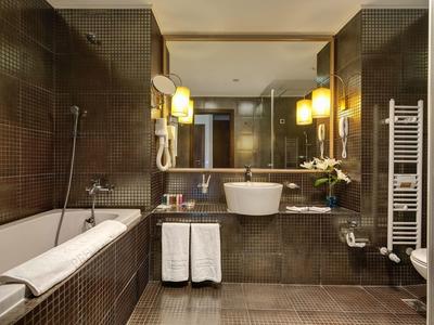 Moderne Hotelbadezimmer mit Badewanne, Waschbecken, Spiegel und Handtüchern