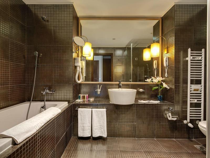 Moderne Hotelbadezimmer mit Badewanne, Waschbecken, Spiegel und Handtüchern