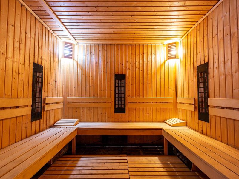 Gemütliche Sauna mit Holzbänken und warmem Licht.