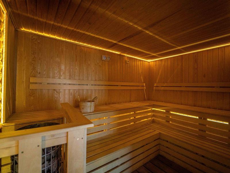 Dřevěná sauna s jemným LED osvětlením podél stěn a stropu, moderní a útulná atmosféra.