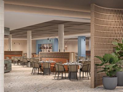 Moderner Hotel-Lobby mit hellen Böden, runden Tischen, Holzstruktur und grünen Pflanzen.