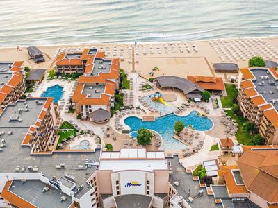 Strandhotel mit mehreren Gebäuden, Poollandschaft und direktem Zugang zum Sandstrand am Meer.