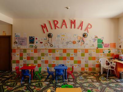 Bunte Kinderspielecke mit Tischen, Stühlen und Wanddekoration im Miramar-Hotel.