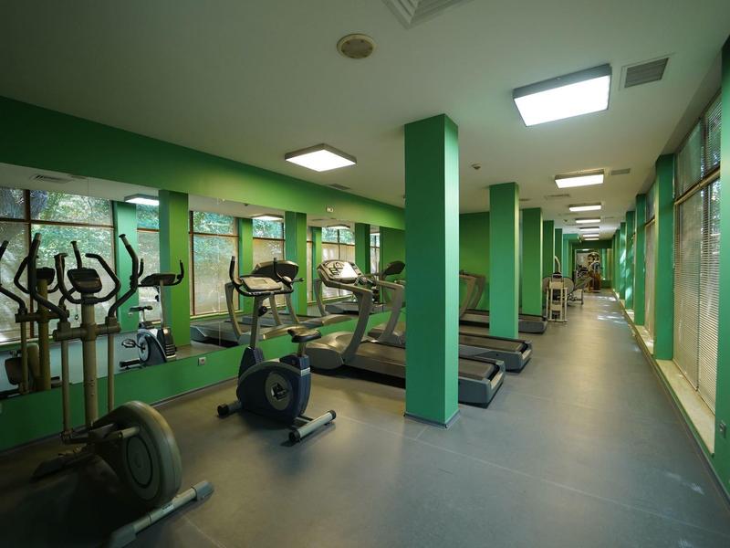 Gimnasio moderno con cintas de correr, bicicletas y máquinas elípticas en un hotel.