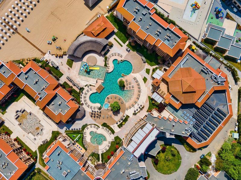 Vista aérea de un hotel con varios edificios, piscinas y áreas exteriores cuidadas.