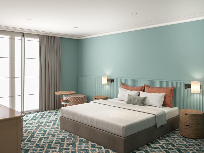 Habitación de hotel moderna con cama grande y paredes gris azuladas.