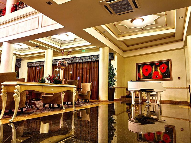 Großer Raum mit glänzendem Fußboden, eleganten Säulen, Tischen und rotem Bild an der Wand.