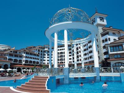 Piscina moderna del hotel con estructura de columnas blancas y agua azul bajo cielo despejado.