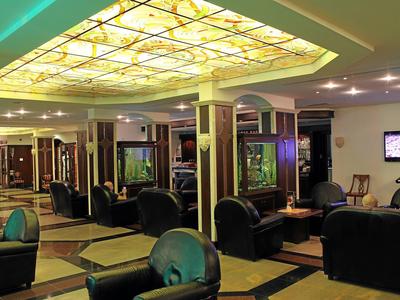 Amplio vestíbulo de hotel con cómodos sillones de cuero y iluminación ambiental.