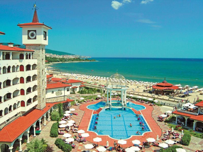 Gran hotel con piscina y vista a la playa y el mar bajo un cielo despejado.