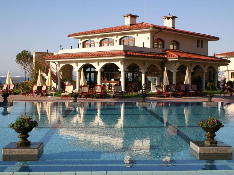 Villa lujosa con gran piscina y terraza cubierta en lugar soleado.