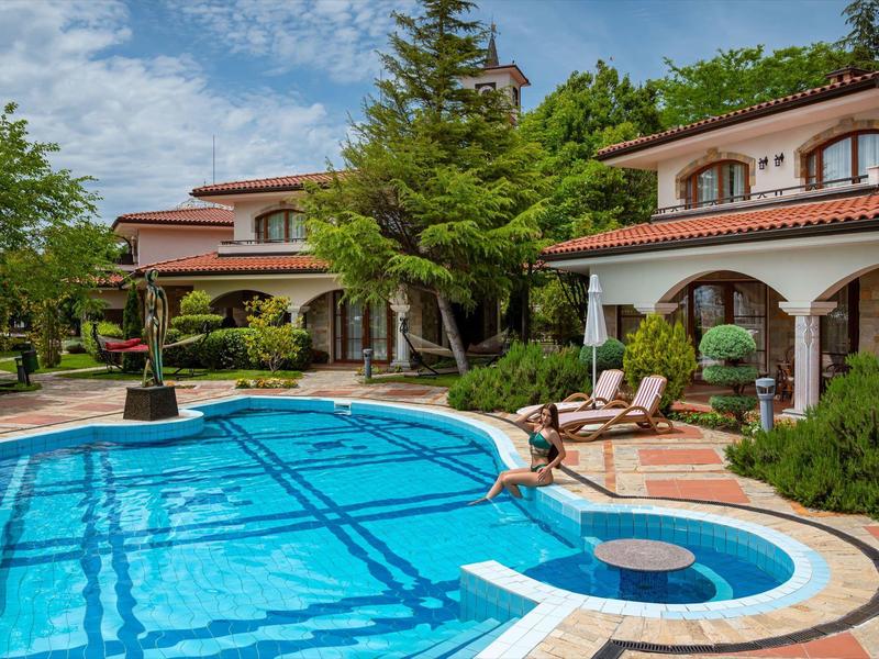 Piscina grande y limpia rodeada de tumbonas y vegetación en un hotel acogedor