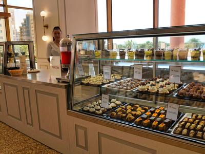 Display case with assorted pastries in a café or hotel buffet.
