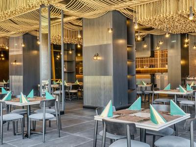 Modernes Hotelrestaurant mit elegant gedeckten Tischen und stilvoller Beleuchtung.