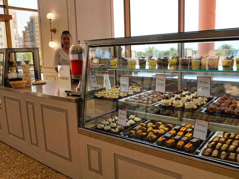 Display case with assorted pastries in a café or hotel buffet.