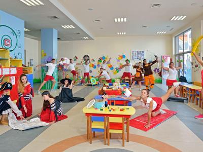 Colorful children's playroom with kids and caregivers in a lively atmosphere.