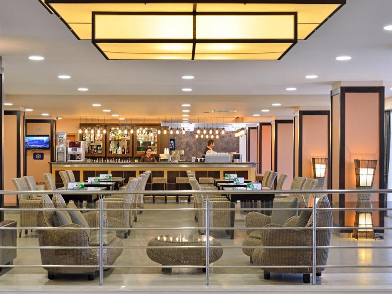 Bar dell'hotel elegante con design moderno, aree salotto e banco ben illuminato