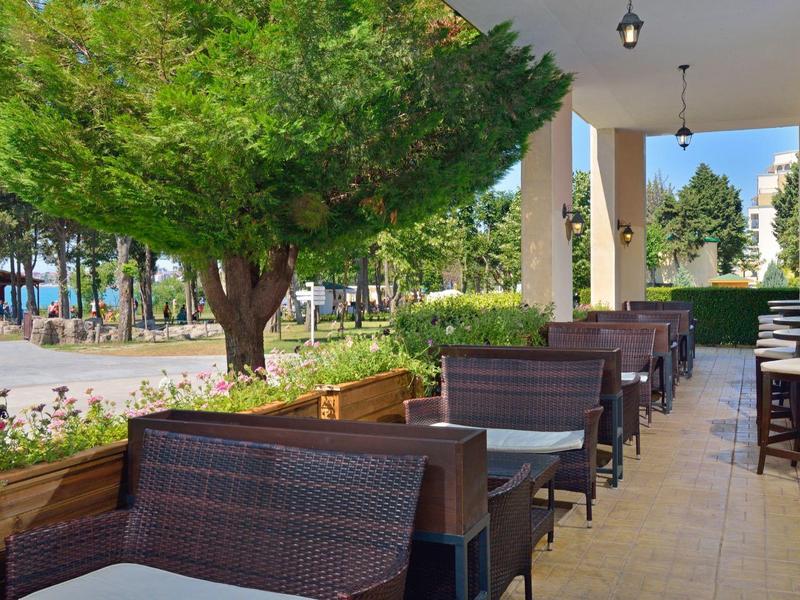 Terrazza esterna coperta con posti a sedere e vista sull'orizzonte del mare.