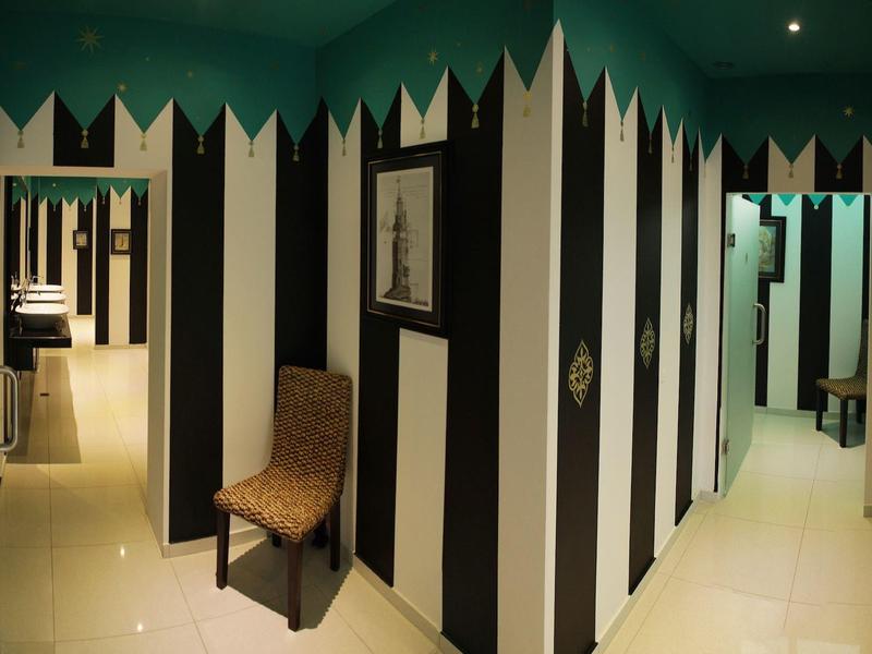 Interior with striped walls, chair, and multiple doors in a hotel corridor.