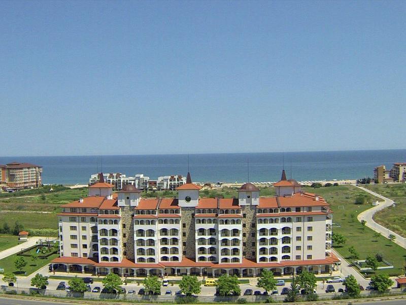 Large residential complex with red roofs near coast and blue sky
