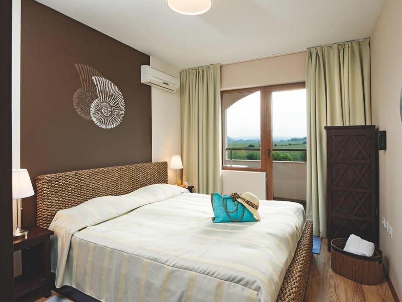 Cozy fire pit with green chairs on gravel near the sea at dusk