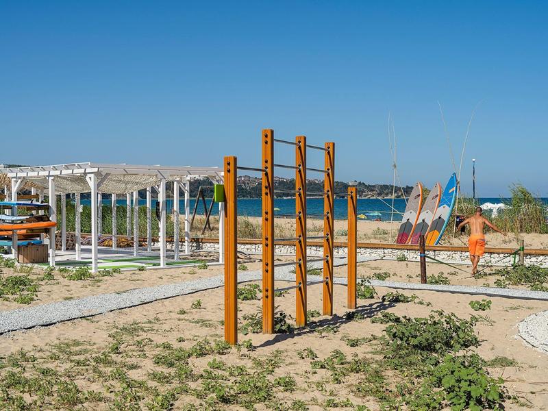 Climbing frame and pergola on sandy beach with sea in the background on sunny day