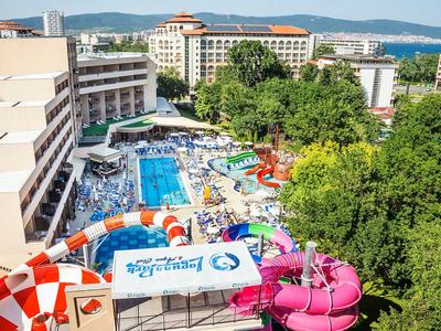 Großer Freizeitpark mit bunten Wasserrutschen, mehreren Pools und umliegenden Gebäuden im Sommer.