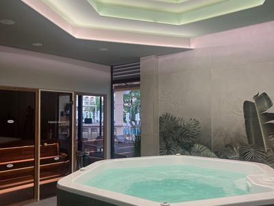 Moderní wellness s vířivkou a saunou, tlumené osvětlení a stylové stropní světlo