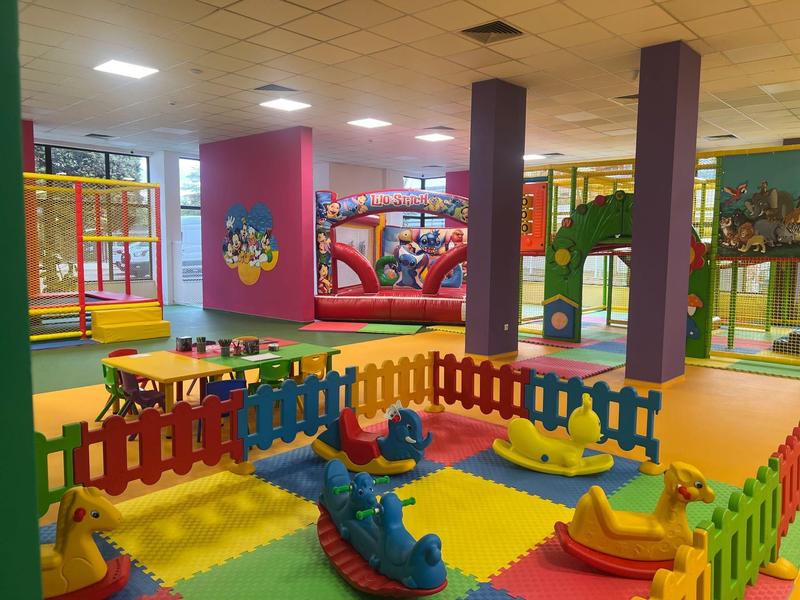 Barevné kryté hřiště s měkkými podložkami a skákacími hrady v hotelové herně.