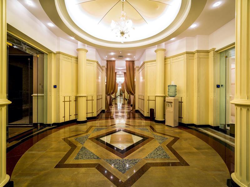 Großer, eleganter Korridor mit Marmorfußboden und runder Deckenbeleuchtung.