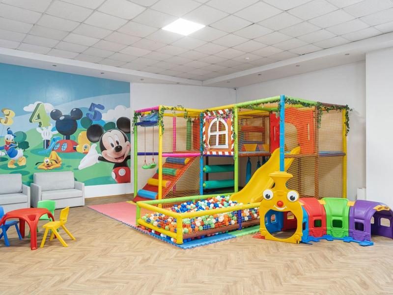 Colorful children's playroom with climbing frame, ball pit, and child-friendly furniture.