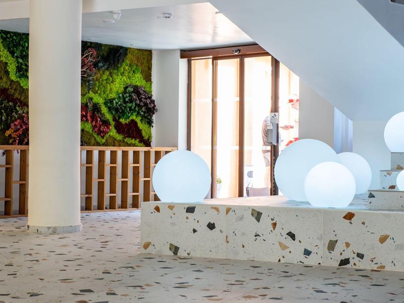 Modern hotel interior with illuminated spherical lights and colorful wall art.