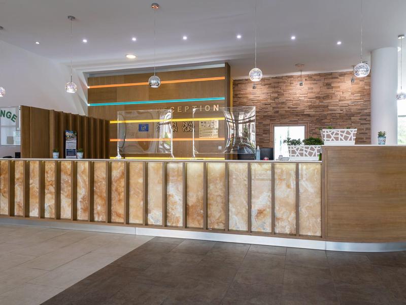 Moderne hotel lobby met lange houten receptiebalie en subtiele plafondverlichting