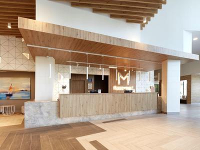 Área de recepción moderna con paneles de madera y diseño simple y luminoso.