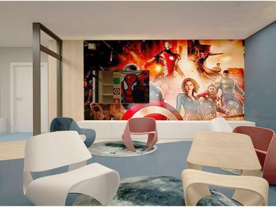 Área de salón moderna en hotel con sillas elegantes y una gran decoración mural de película Marvel.