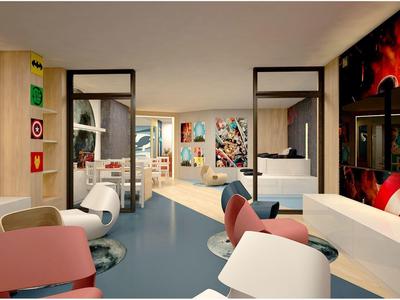 Habitación de hotel moderna y colorida con decoración de superhéroes y varias áreas de estar.