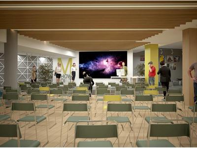 Gran sala de conferencias con sillas verdes, personas y pantalla para presentaciones.