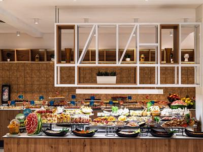 Buffet con una variedad de comidas frescas y frutas en un restaurante moderno.