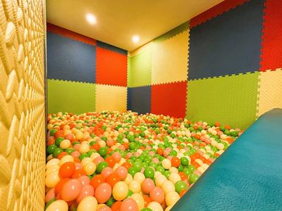 Sala con piscina de bolas coloridas y paredes acolchadas para niños en un hotel