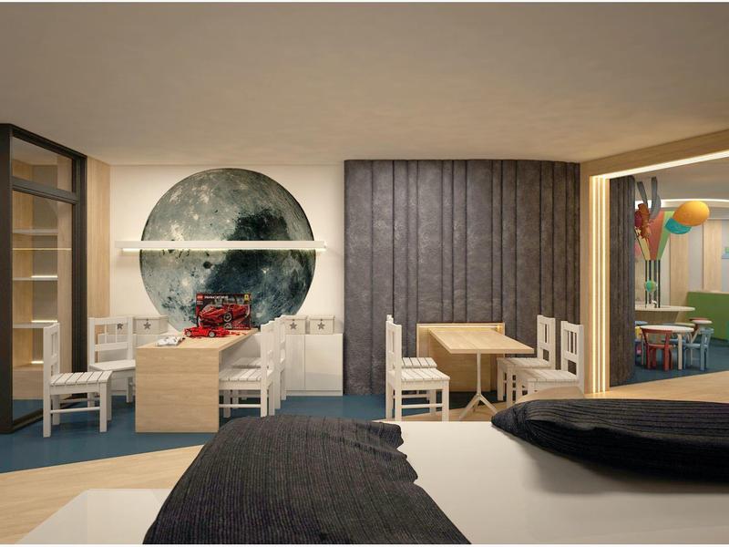 Habitación de hotel moderna con cama doble, área de estar y decoraciones de pared coloridas.