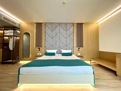 Modernes Hotelzimmer mit Doppelbett, blauen Akzenten und offenem Kleiderschrank.