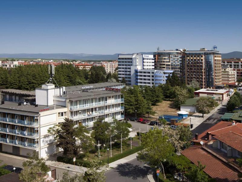 Städtische Landschaft mit modernen Wohn- und Bürogebäuden unter klarem, blauem Himmel.