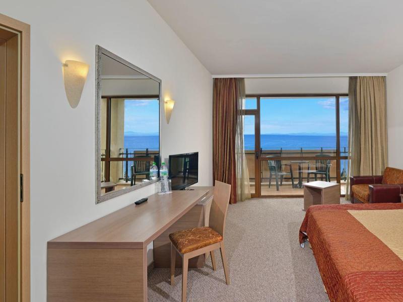 Hotelzimmer mit großen Betten, Meerblick und Balkon.