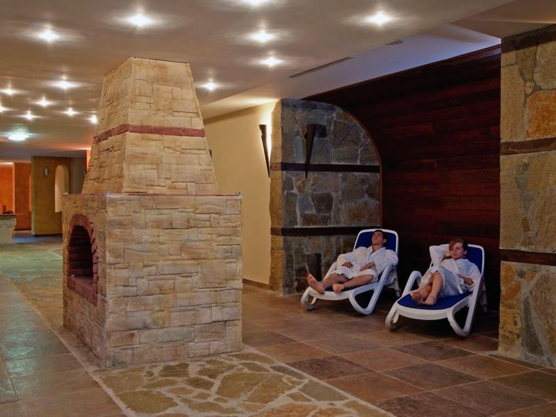 Kinderspielplatz mit Schlitteln und Rutsche in bewaldetem, gebirgigem Urlaubsgebiet.