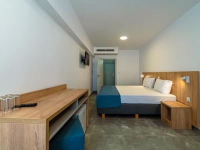 Modernes Hotelzimmer mit Doppelbett, Holzmöbeln und minimalistischem Design.