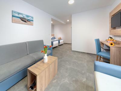 Modern eingerichteter Hotelzimmer-Lounge-Bereich mit Sofa, Tisch und Schreibtisch.