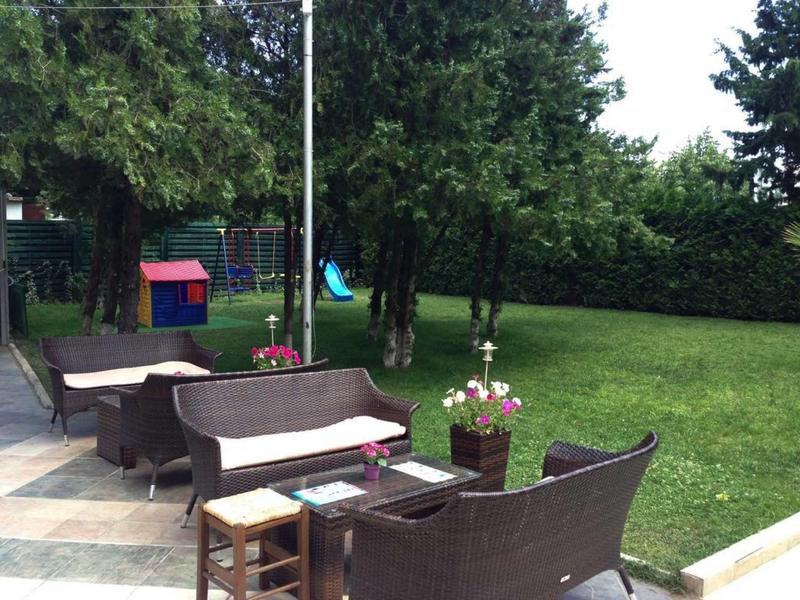 Gezellig tuingebied met rieten meubels en bloemstukken in een hotel tuin.