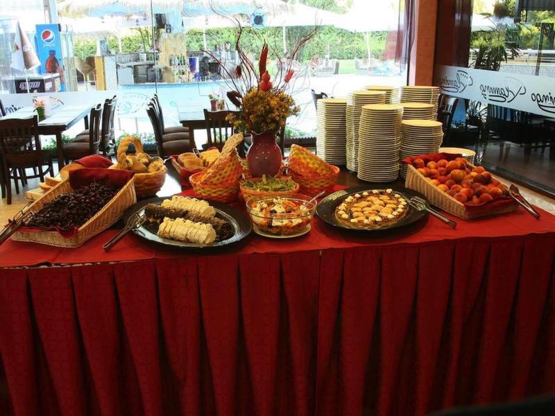 Buffettafel met diverse hapjes en broden in een restaurant met uitzicht naar buiten.