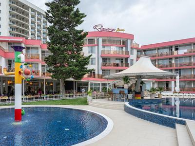 Hotel met buitenzwembad, paviljoen en meerlaagse gebouwen onder bewolkte lucht.